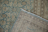 Folded corner of a distressed Tabriz showing the hand-knotted back and low pile.