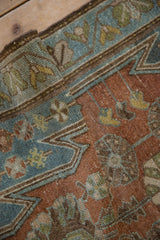 Detail of the meandering vine border and serrated spandrel in dusty blue and cochineal red.