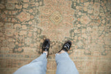 Low pile texture of a distressed Hamadan rug with dusty teal and coral floral sprays.