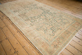 Angled view of the vintage Hamadan rug runner's distressed texture and faded floral design.