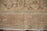 Close-up of the distressed rug's worn knot heads and faint foundation showing through.