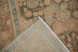 A corner of the vintage Hamadan rug folded back to show the fine, hand-knotted weave.