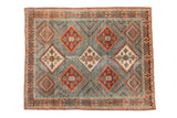 Vintage distressed Afshar rug with geometric diamond medallions in red-rust and ivory on a dusty blue field.