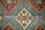 Detailed view of hook and latch designs within diamond-shaped guls on a distressed Afshar rug.