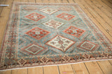 Angled view of a vintage distressed Afshar rug showing its geometric diamond pattern.