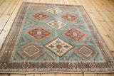 Angled perspective of a vintage Afshar rug's geometric diamond gul and trellis design.