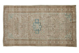Distressed vintage Mehriban rug with a dusty teal medallion and allover floral pattern in sand and beige.