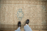 Evenly worn, low-pile texture of a vintage Mehriban rug with a dusty teal medallion and beige field.