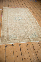 Low angle highlights the time-softened neutral tones and even wear of a vintage Persian rug.