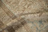 The low, even pile of a distressed Mehriban rug showing visible knot heads in sand, brown, and dusty green.