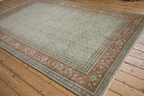 Angled corner view of a vintage Tabriz carpet showing the rust turtle motif border and low-pile texture.