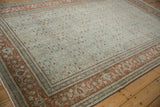 Angled perspective of the distressed Tabriz carpet's low-pile, showing the rust border and teal field.
