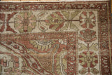 Corner of a distressed Baktiari rug showing its low pile and detailed floral borders.