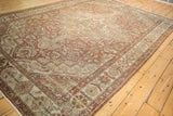 Angled perspective on a vintage Baktiari carpet, showing its distressed texture and geometric medallion.