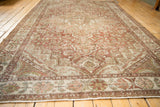 Full length perspective of a distressed Persian Baktiari carpet with a dusty chestnut and ivory palette.