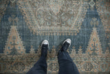 Distressed texture of a vintage Veece rug with dusty denim blue and beige tones worn to the foundation.