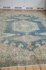 Low-angle view of a vintage distressed rug highlighting its worn texture and faded denim blue palette.