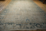 Lengthwise view of a vintage distressed Heriz showing heavy abrashes and low pile.