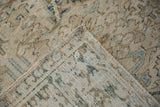Flipped corner of a distressed Heriz carpet revealing its hand-knotted back and secured selvage.