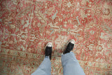 Personal view of a distressed Heriz rug's low-pile texture in dusty ruby and slate blue tones.