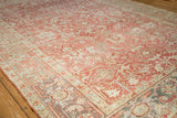 Angled view of a distressed Heriz carpet's serrated leaf field and Turtle Samovar border motif.