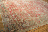Angled perspective of a distressed Heriz carpet showing the slate blue Turtle Samovar border and ruby red field.