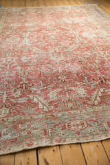 A low angle view highlighting the character-rich patina and low pile of a distressed Heriz carpet.