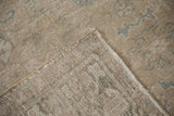 Distressed Heriz carpet's worn beige and blue pile, revealing hand-knotted foundation and selvage.