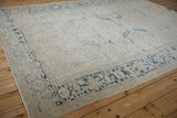 Distressed corner of the Mehrivan rug with dusty blue Turtle Samovar border and floral patterns.