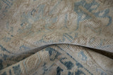 Textured, worn pile of a distressed Mehrivan carpet in ivory, beige, and dusty blue.