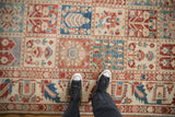 Close-up of the vintage Baktiari carpet's four-seasons panel design in cherry red and dusty blue.