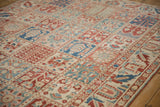 Angled shot highlighting the paneled design and worn texture of a vintage Baktiari carpet.