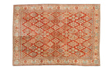 Vintage distressed Joshegan rug with allover diamond-shaped floral clusters in cherry red and ivory.