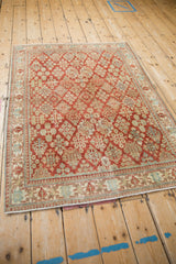 Angled full view of the distressed vintage Joshegan rug, showcasing its allover floral design and soft, even wear.