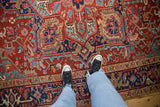 A perspective view of a vintage Heriz rug's hand-knotted pile and vibrant gem-toned geometric pattern.