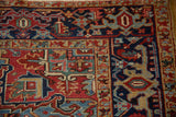 A close-up of the vintage Heriz carpet's Turtle Samovar border in gem-tones of ruby and sapphire.
