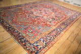 Sapphire blue Turtle Samovar border framing the geometric ruby red field of a vintage Persian Heriz carpet.