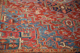 Textured, hand-knotted pile of a vintage Heriz rug with geometric vines in ruby red and sapphire blue.