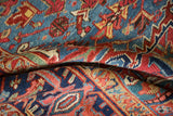 Soft, low pile of a vintage Heriz carpet showing sapphire blue and ruby red geometric patterns.