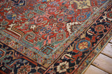 Hand knotted Vintage Heriz carpet corner detail: brick red scrolled field, navy Turtle Samovar border.