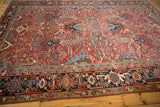 Vintage Heriz carpet's navy border showcases Turtle Samovar motifs and brick red arabesque field.