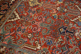 Detail of vintage Heriz rug, brick red field, scrolled serrated leaves, blue, dusty green blossoms.
