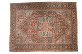 Vintage distressed Heriz carpet with a large geometric medallion in a faded palette of burgundy red and powder blue.