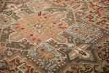 Angled view of the even wear on a vintage Heriz carpet's geometric motifs.