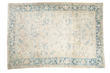 Vintage distressed Heriz carpet with an allover floral design in ivory, sand, and dusty blue tones.
