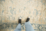Mostly even wear on the low pile of a distressed Heriz carpet with blue arabesques.