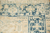 Close-up of the Turtle Samovar border motif and low pile on a distressed Persian Heriz carpet.
