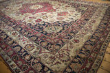 Antique Kerman carpet corner: palmette arabesque border, floral field, cochineal, navy, ivory.