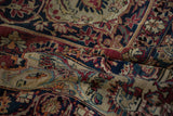Antique Kerman carpet pile showing detailed floral vines in rich cochineal, navy, and aged ivory.