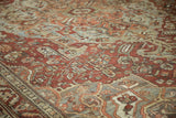 Vintage distressed Baktiari carpet's decorative field with time-softened red, blue, and green floral vines.